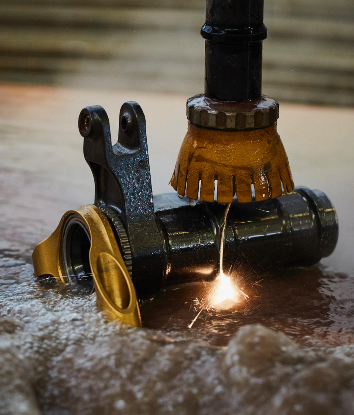 Close-up  of a F1 metal component being cutting with a water cutter creating sparks. 