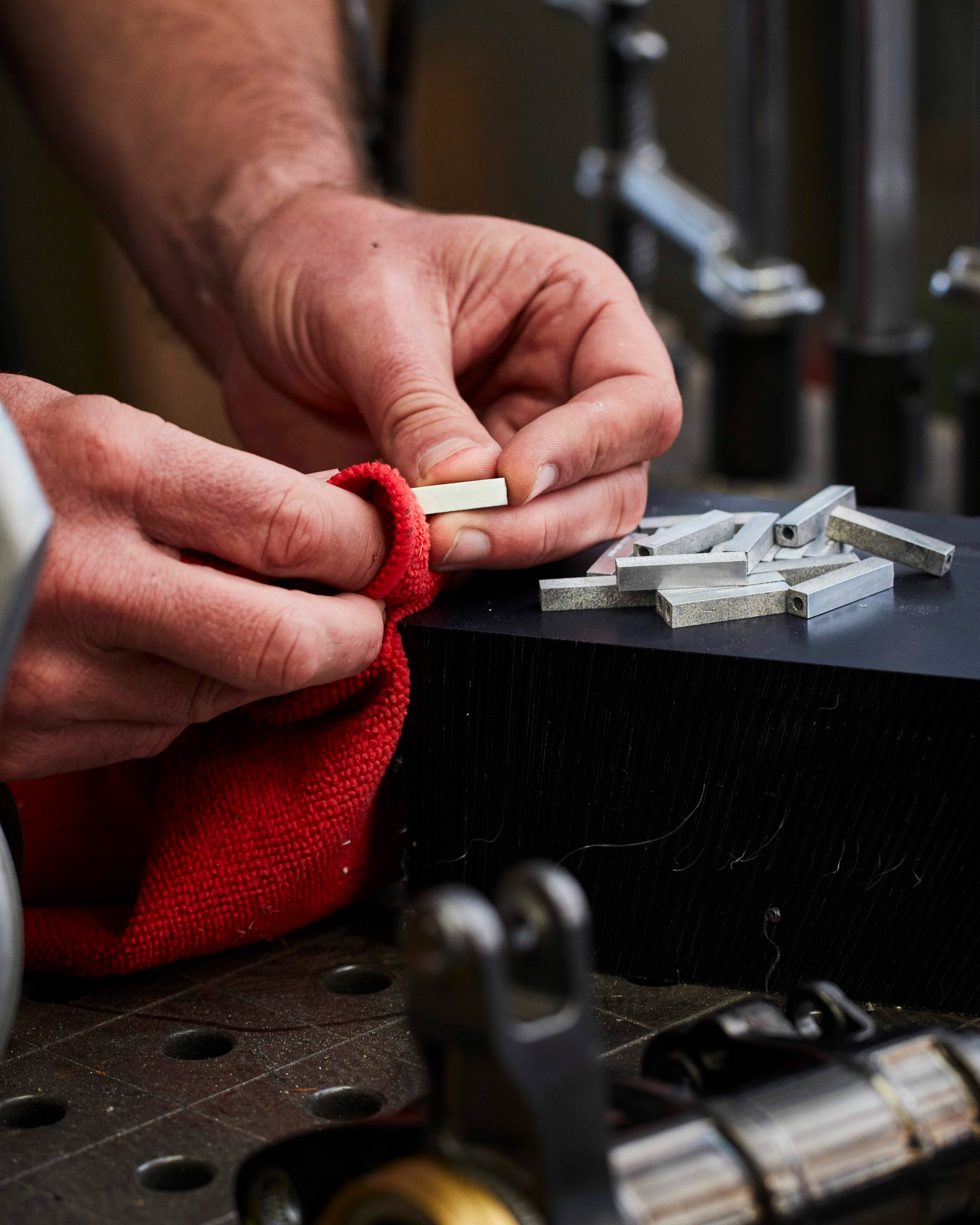 raw RESS Jewellery blocks which are made from F1 Cars being polished by hand in the RESS Factory. 